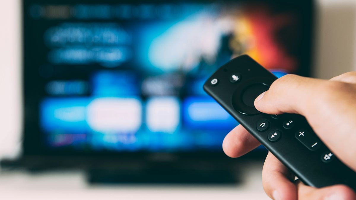 A technician holding a TV box remote and IPTV device setup in Panama